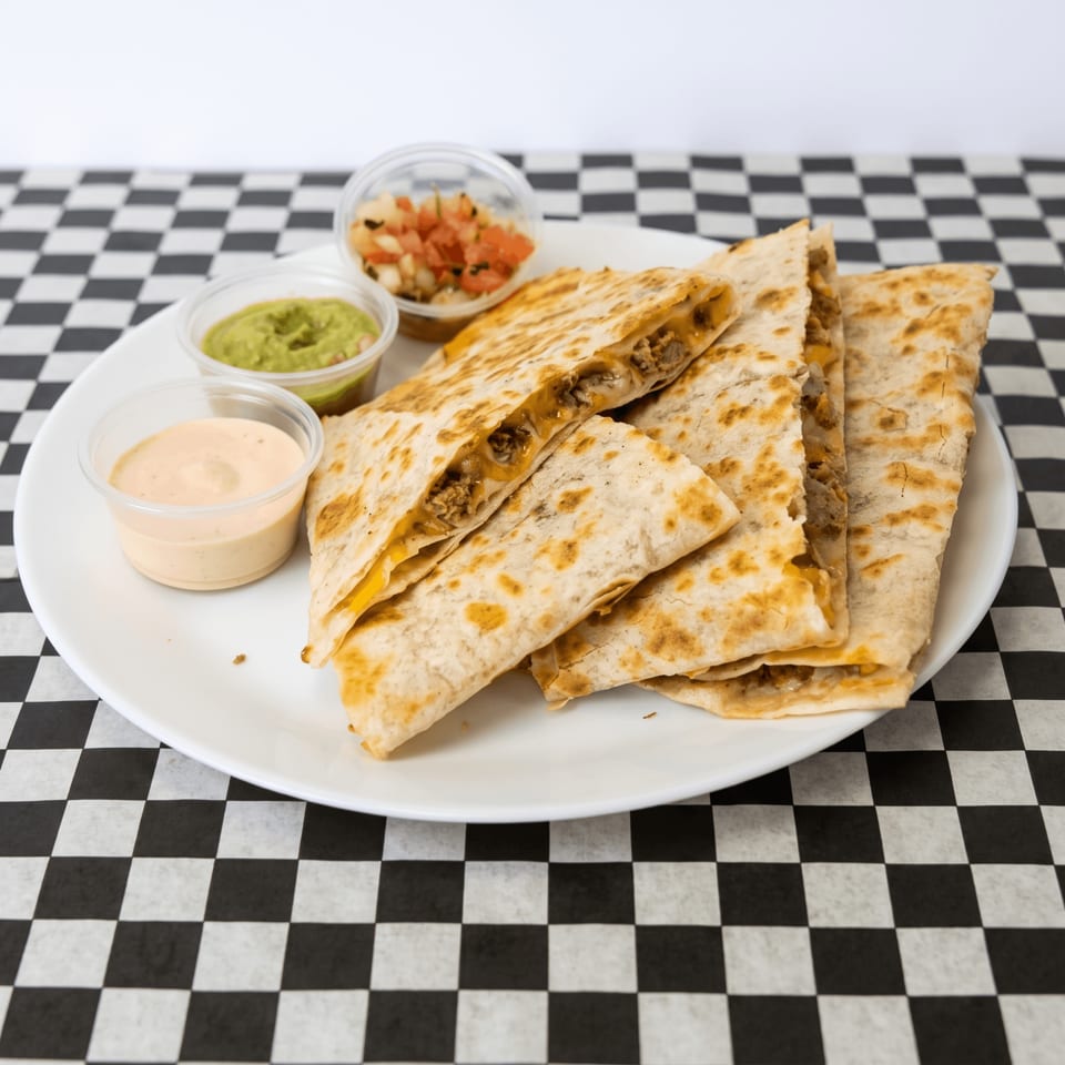 Golden-brown quesadillas filled with meat and cheese, served with guacamole, salsa, and a creamy dip.
